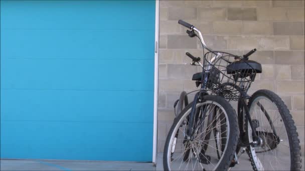 Dos bicicletas apoyadas en una pared fuera de una casa — Vídeo de stock