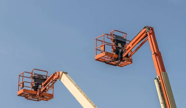 Two Cherry Picker Machines