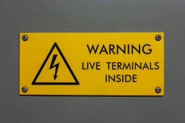 Live terminals inside warning sign