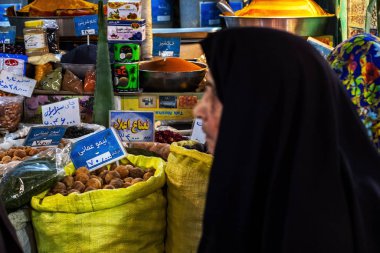 İsfahan, İran - Kasım 2019. Chador 'daki kadın, Qeysarriyeh Çarşısı, Qeysarie Çarşısı veya Soltani Çarşısı olarak da bilinen Grand Bazaar' ın yanında yürüyor. Mala odaklan, kadın bulanık.