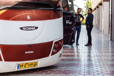 İsfahan, İran - Kasım 2019. Otobüs durağının platformunda otobüsler. Otobüsün yanında iki şoför var..