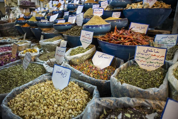 Shiraz, İran - Kasım 2019. Doğu Çarşısı 'ndaki bir baharat dükkanında kurutulmuş aromatik otlar ve baharatlarla dolu poşetler ve kaseler..