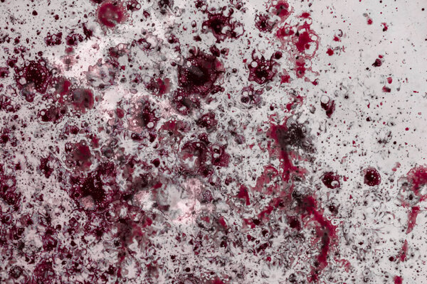 Ярко-красная краска распыляется на светло-розовую поверхность. Абстрактный фон
.