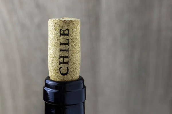 Ahşap arka planda mantarlı bir şişe boynu. Şili 'nin şarap ülkesinin adı mantarda yazılı..