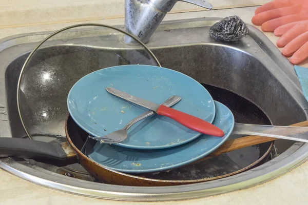 Pile of dirty dishes in a sink in kitchen.