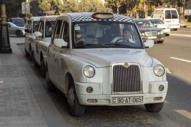 Bakü, Azerbaycan - Kasım 2019. Geleneksel beyaz taksi şehir merkezine park etmiş..