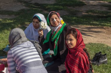 İsfahan, İran - Kasım 2019. İranlı bir grup kadın ve kız İmam Meydanı 'nda çimlerin üzerinde piknik düzenliyorlar..