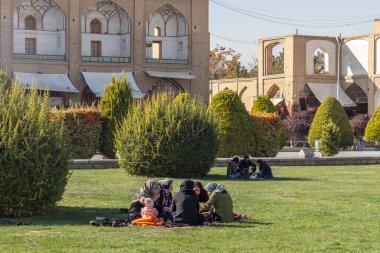 İsfahan, İran - Kasım 2019. İmam Meydanı 'nda İranlı gruplar otların üzerinde dinleniyor..