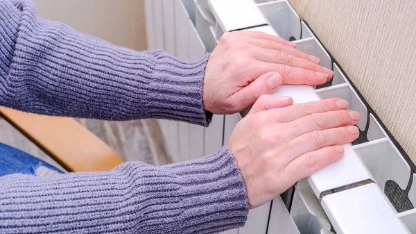 Eine kalte Batterie auf weißem Hintergrund. weißer Hintergrund. die gefrorenen Hände. — Stockfoto