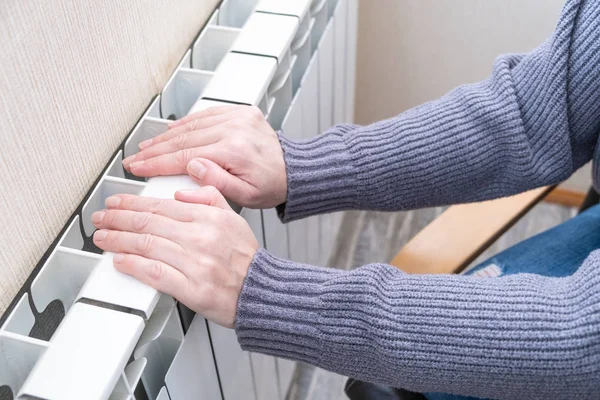 Eine kalte Batterie auf weißem Hintergrund. weißer Hintergrund. die gefrorenen Hände. — Stockfoto