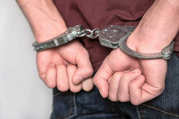 The criminal was detained by the police. The handcuffed hands clenched into fists. — Stock Photo, Image