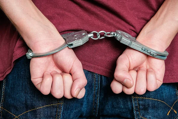 The criminal was detained by the police. The handcuffed hands clenched into fists. — Stock Photo, Image