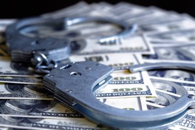 Yüksek rütbeli bir memurun rüşvetten tutuklanması. Para ve kelepçe. Yasa ve suç. Yasadışı zenginleştirme.