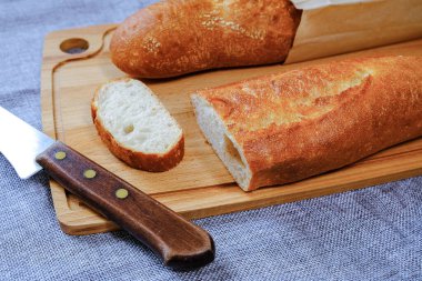 Blurred focus, artistic blur. Soft plan. Fresh warm baguette with a crispy crust. Sliced for Breakfast. For the morning sandwich.