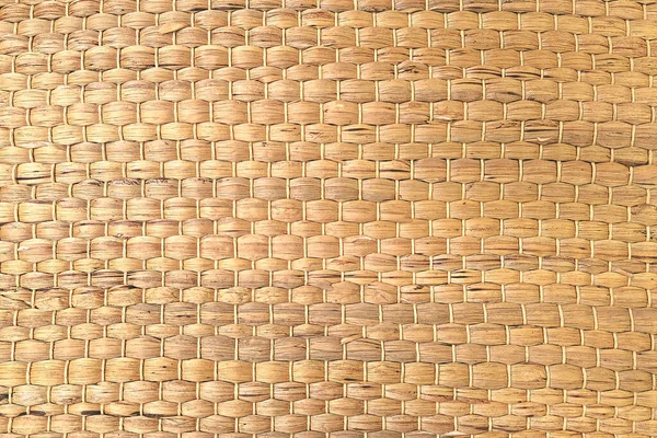 Een geweven Mat van riet of stro-geel van kleur. De textuur van droog riet. Lichtgeel. — Stockfoto