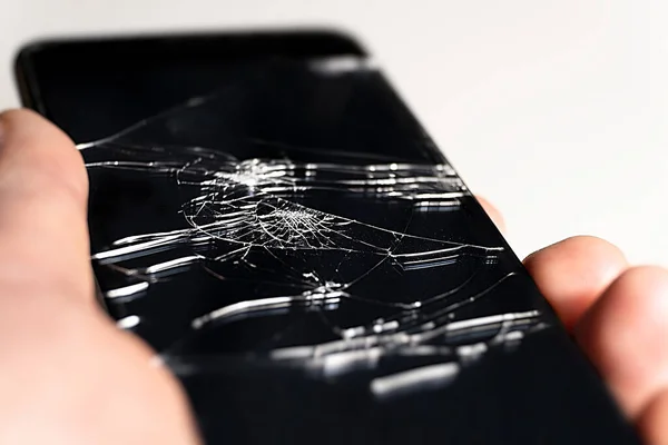 Broken smartphone glass. Phone repair. Selective focus of cracks on the screen