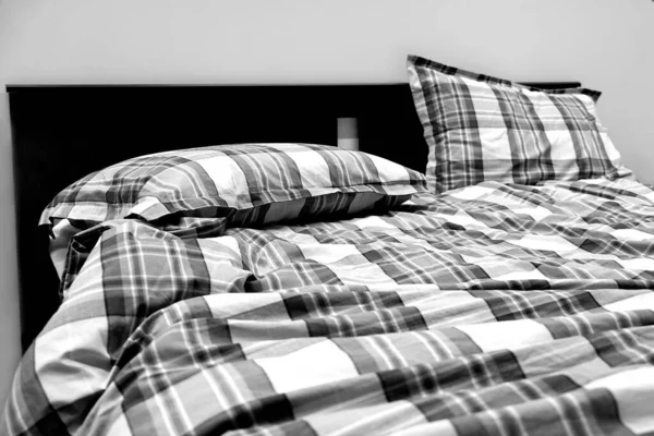O sol brilha através da janela do quarto. Mantas de cama e almofadas não feitas não são acondicionadas . — Fotografia de Stock