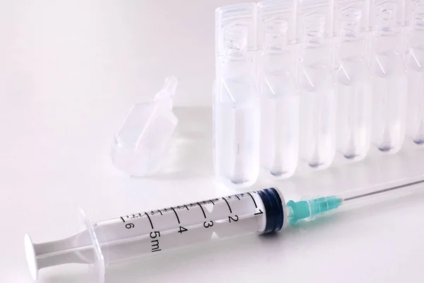 Sprutor, vatten för injektionsvätskor, injektionsflaskor med vaccin. Begreppet vaccinering. — Stockfoto