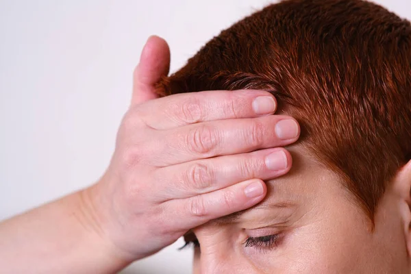 Die Frau legte ihre Hand auf die Stirn und hatte Kopfschmerzen. Migräne, Fieber, Blutdruck. Krankheitssymptome. — Stockfoto