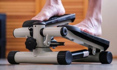 Ayakları rehabilitasyon simülatörünün pedallarına basıyor. Yaralandıktan sonra ayak bileğinin iyileşmesi..