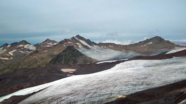 gray snow lies in the mountains