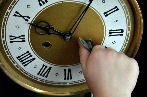 Children's hand turns on the clock