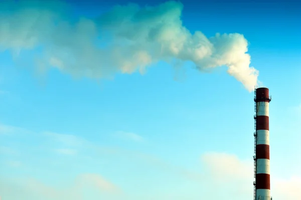 青い空に向かって煙突から煙が出て — ストック写真
