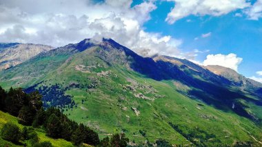 Dağların üzerinden beyaz bulutlar uçuyor