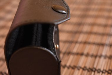 Siyah deri çanta saman arka planda