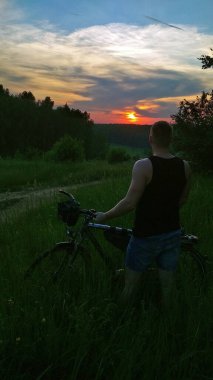 Gün batımında bisikletli bir adam.