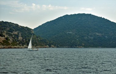 Yat denizde yelken açar kayalıklar boyunca