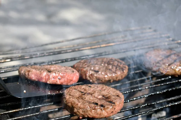 Izgarada hamburger yapma süreci.