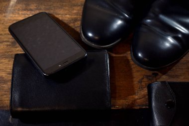 Siyah erkek gardırobu. ayakkabılar, cüzdan, telefon