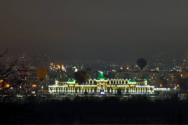 Balonlar gece şehrinin üzerinde uçuyor