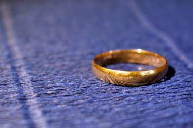 Mavi arka planda altın nişan yüzüğü