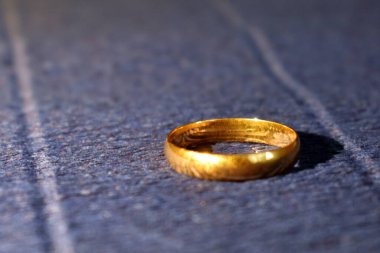 Mavi arka planda altın nişan yüzüğü