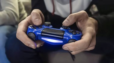 Adam oyun alanını elinde tutuyor, oyun oynuyor. Oyunculardan biri, kapatın.