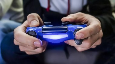 Erkek eller konsol kumandasını tutuyor, video oyunu oynuyor. Bir oyuncu, yakın plan.