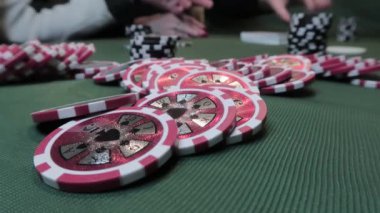 Poker oynayan insanların arka planında yeşil kumaş üzerinde poker fişleri yakın plan