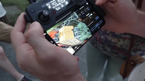 Ein Mann hält eine ferngesteuerte Drohne mit Smartphone in der Hand. Auf dem Bildschirm die farbenfrohen Häuser in Großaufnahme — Stockvideo