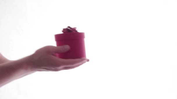 Man handen reiken een geschenkdoos en vrouw handen nemen het op witte achtergrond — Stockvideo