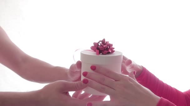 클로즈업. 남자들은 흰색 바탕에 붉은 활 이달려 있는 흰색 선물 상자를 손에서 손으로 줍니다. 고립되어 있습니다. 성 발렌타인데이, 국제 여성의 날, 생일, 휴일 컨셉트. 조롱하다 — 비디오