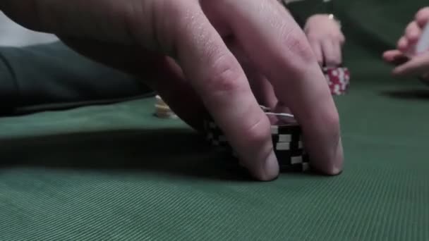 Close-up de mãos masculinas usando fichas de poker na mesa de poker no fundo de pano verde. O conceito de lazer — Vídeo de Stock