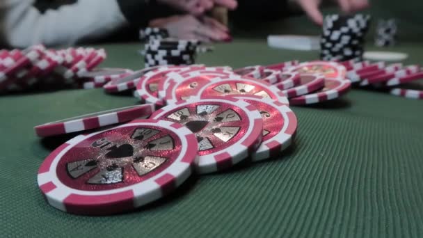 Close-up of poker chips on green cloth on a background of playing poker people — Stock Video