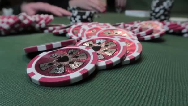 Close-up of poker chips on green cloth on a background of playing poker people — Stock Video