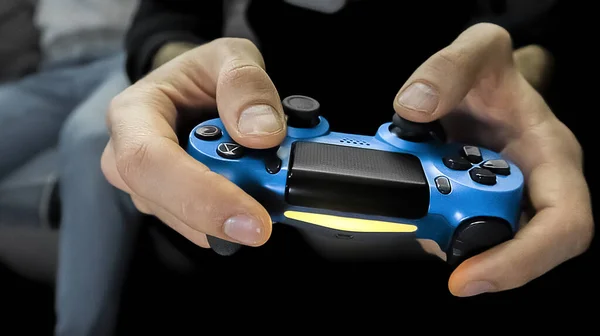 Front view of male hands holding the gamepad playing video game. One gamer person, close-up