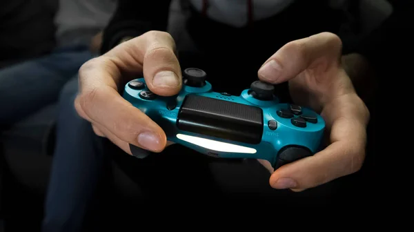 Mannelijke handen die een gamepad vasthouden. Een gamer persoon, close-up, vooraanzicht Stockfoto