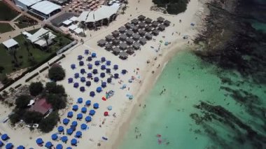 Kıbrıs 'taki güzel kumlu Nissi plajının insansız hava aracı manzarası. Temiz turkuaz su ve kayalık bir tabanı var.