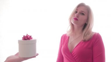 Kırmızı rujlu üzgün kız erkeklerin elinden bir hediye alıyor, şaşırmış ve memnun olmuş. İnsanlar ve hediyeler. Neşeli bir ruh hali. Aşk ve aşk. Sevgililer Günü, Uluslararası Kadınlar Günü