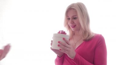 Kız, erkeklerin elinden bir hediye alıyor, açıyor ve sevinçten zıplıyor. İnsanlar ve hediyeler. Neşeli bir ruh hali. Aşk ve aşk